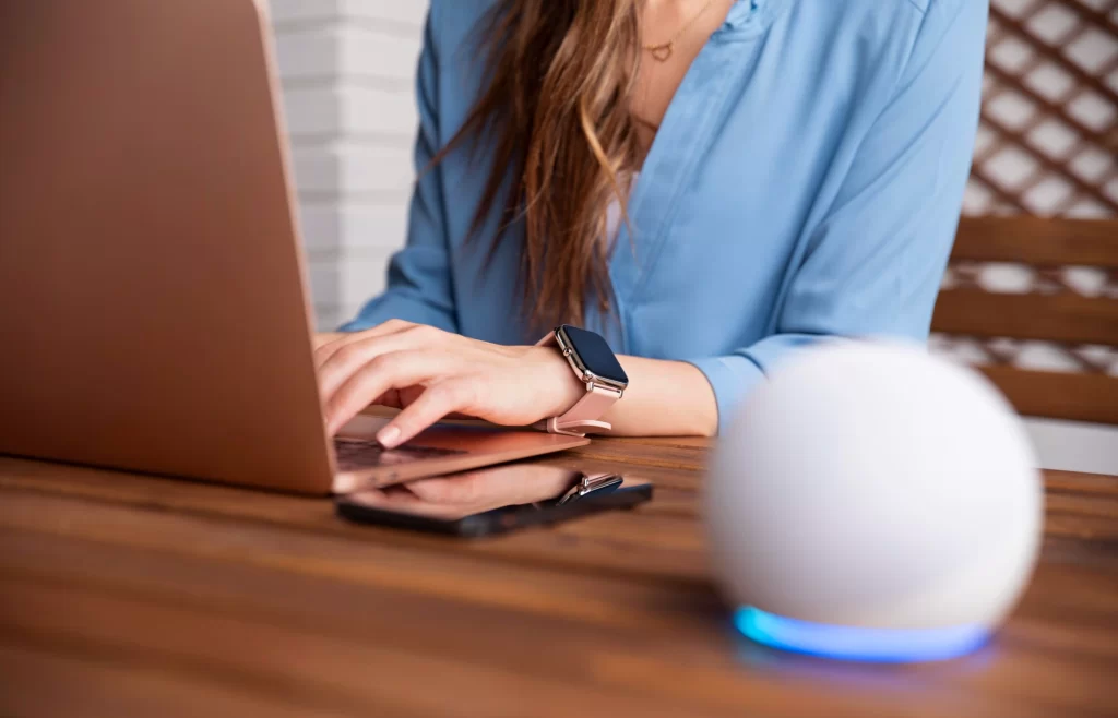 Full Guide of AI Voice Assistant for Your Business: Key Types, Applications, and Reasons to Invest 1 Women is working with an AI voice assistant