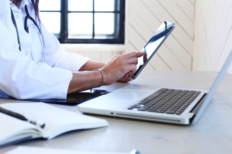 Doctor wearing white robe with a tablet